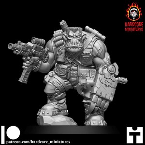Peut inclure: Une figurine miniature grise non peinte représentant un soldat orc musclé avec une coupe en brosse. La figurine tient une arme à feu futuriste dans la main droite et une grande pince mécanique sur le bras gauche. Elle porte un équipement tactique.