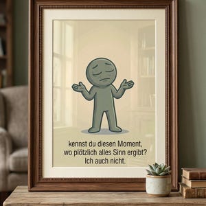 May include: Framed artwork featuring a cartoon figure with arms outstretched, conveying a sense of confusion. The text reads, "Do you know that moment when everything suddenly makes sense? Me neither." The frame is brown, and the artwork is displayed on a wooden table.