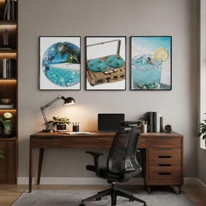 May include: Three framed wall art prints displayed above a wooden desk. The left print shows a disco ball reflecting a tropical beach. The center print features a vintage reel-to-reel tape recorder. The right print depicts a blue cocktail with a lemon slice.