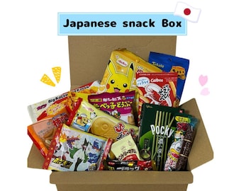 May include: A cardboard box filled with various Japanese snacks. The box contains colorful packages of chips, cookies, and candies, including Pocky sticks and a Pikachu-themed snack. The text "Japanese snack Box" is displayed on top.