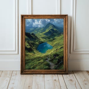Könnte beinhalten: Ein gerahmtes Landschaftsgemälde, das ein leuchtend grünes Bergtal mit einem zentralen blauen See und einem gewundenen Steinpfad zum Wasser zeigt, eingefasst in einen dunkelbraunen Holzrahmen mit einer strukturierten, klassischen Oberfläche.