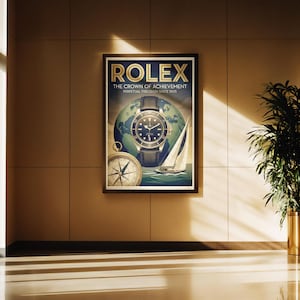 Puede incluir: Un póster enmarcado con el logotipo de Rolex y el texto "The Crown of Achievement" con un reloj, un globo terráqueo, una brújula y un velero. El póster se muestra en una pared marrón con luz solar.