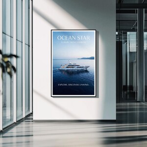 May include: A framed poster featuring a luxury yacht on the sea, with the text "OCEAN STAR" and "EXPLORE. DISCOVER. UNWIND." The poster is displayed on a white wall in a modern building with large windows and a polished floor.
