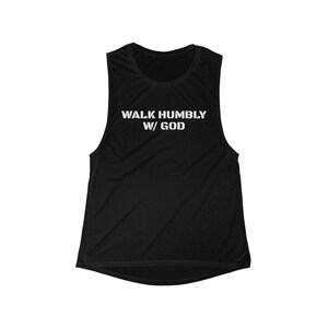 May include: Black sleeveless workout top with the text "WALK HUMBLY W/ GOD" in white block letters. The top has a scoop neck and a racerback design. The fabric appears to be a soft, breathable material.