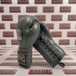 May include: A pair of gray leather boxing gloves with the brand name "CLETO REYES PROFESSIONAL" visible on the wrist strap and the glove. The gloves are laced up and appear to be new.