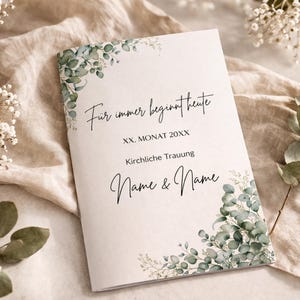 Könnte beinhalten: Ein weißes Kirchenheft für die Hochzeit mit grünen Eukalyptusblatt-Illustrationen in den Ecken. Der Text lautet: Für immer beginnt heute, XX. MONAT 20XX, Kirchliche Trauung, Name & Name, gedruckt in schwarzer Schreib- und Serifenschrift.