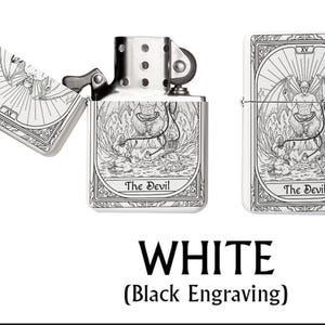 May include: A white metal lighter with a black engraved tarot card design featuring "The Devil" on the front and back. The lighter is shown open and closed, with the text "WHITE (Black Engraving)" below.