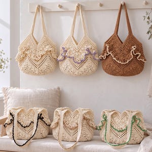 May include: Six crochet tote bags featuring intricate openwork patterns and decorative ruffled edges. Three bags are hung on a wall rack, while three sit on a bench. The bags come in cream and brown, with accent trim in black, purple, and green.
