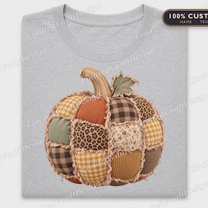Peut inclure: Un t-shirt gris clair arborant un motif central de citrouille composée de divers empiècements en tissu. Le design de la citrouille présente des segments à carreaux marron et blanc, des motifs léopard, orange uni et des imprimés floraux effilochés.