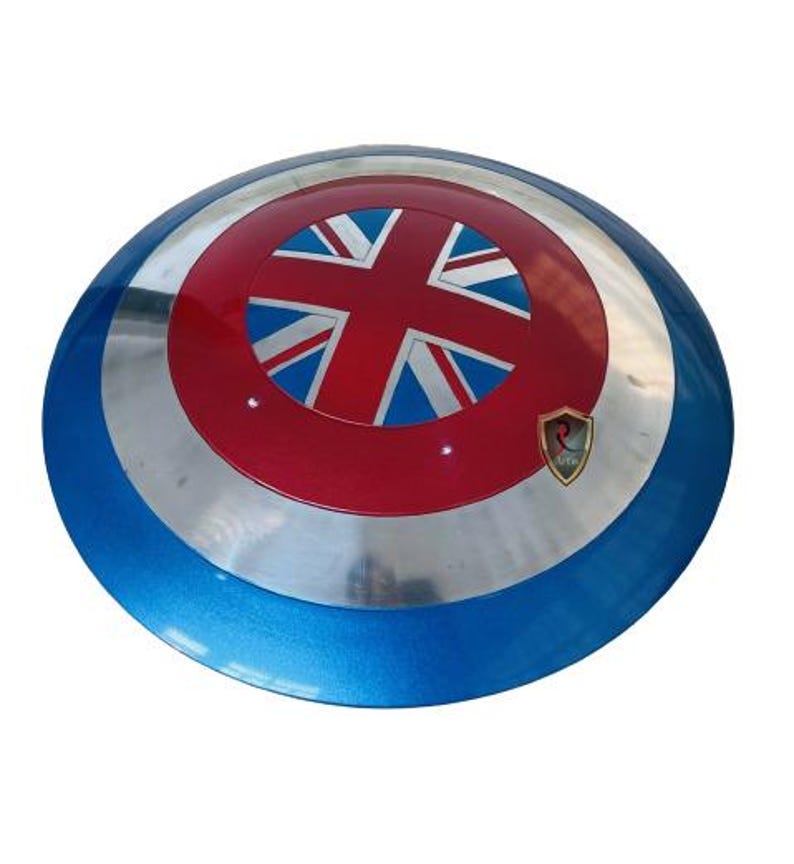 May include: A round shield with a blue, silver, and red color scheme. The center features a red circle with a Union Jack design. A small gold emblem is on the lower right side of the shield.