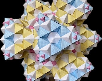 May include: A geometric paper sculpture with a complex, multi-faceted design. The sculpture features a combination of white, yellow, light blue, and pink paper, creating a visually intricate and colorful piece. The paper is folded into triangular shapes, forming a three-dimensional starburst pattern.