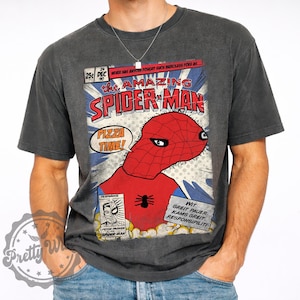 May include: Dark gray t-shirt featuring a comic book-style graphic of Spider-Man with the text "The Amazing Spider-Man" and "Pizza Time!". The design includes a red and blue Spider-Man illustration. The shirt has a vintage, worn look.