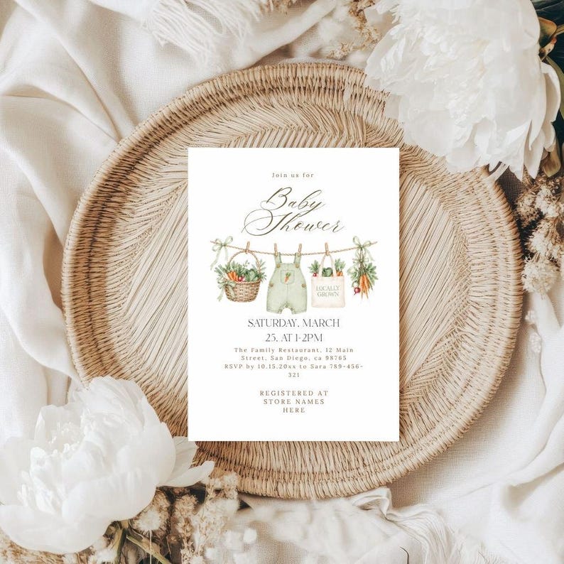 a baby shower invitation with a wicker basket and white flowers as the background.