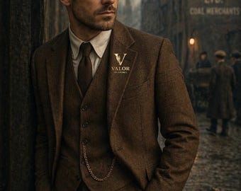 May include: A brown three-piece tweed suit featuring a blazer, a waistcoat with a gold pocket watch chain, and a matching tie over a cream-colored shirt. The blazer lapel displays a gold logo with the text Valor Bespoke.