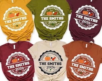 Könnte beinhalten: Sechs kurzärmelige T-Shirts mit Rundhalsausschnitt in Senfgelb, Olivgrün, Kastanienbraun, Dunkelrot, Creme und Rostorange. Jedes Shirt zeigt eine kreisförmige Grafik mit einem Kürbis, dem Text HAPPY THANKSGIVING, THE SMITHS, 2026 und Thankful for my Tribe.