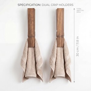May include: Two wooden dual grip towel holders with beige towels hanging from them. The total vertical span is 11.8 inches. The text "SPECIFICATION: DUAL GRIP HOLDERS" is at the top.