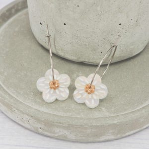 Titanium polished 1 inch hoops, Iridescent white and gold flower dangle charm, Hypoallergenic earrings - Floral