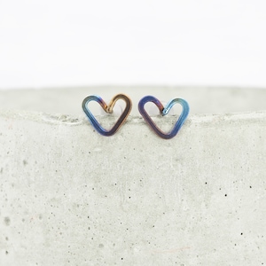 Anodised heart-shaped grade 1 titanium wire stud earrings. They are made from a continuous piece of 0.8mm wire. The hearts measure around 8mm across but may vary slightly due to being handmade. Blue, Yellow and purple tones.