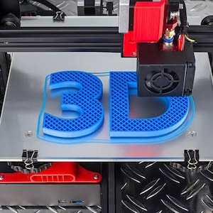 May include: A 3D printer with a black metal frame and red accents is actively printing the blue plastic letters 3D onto a silver build plate. The print head is positioned above the letters, which feature a visible grid infill pattern.
