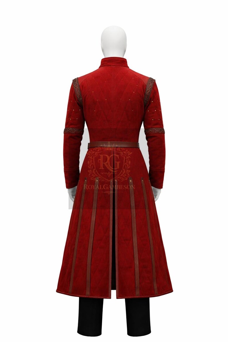 May include: A long-sleeved red gambeson coat featuring a quilted texture, a high collar, and vertical brown leather straps extending from the waist to the hem. The garment includes a brown leather belt and displays the text RG ROYALGAMBESON.