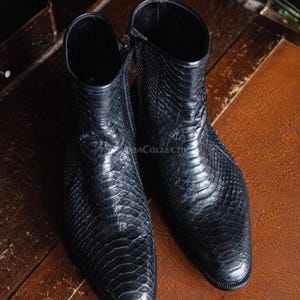 May include: A white ceramic mug with a black handle and the text "But First, Coffee" in a handwritten style. The mug is likely for hot beverages and has a glossy finish.