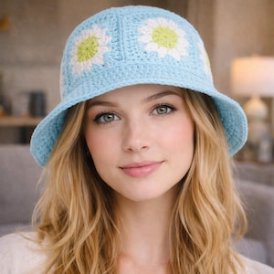 Peut inclure: Un chapeau cloche en crochet bleu clair avec des accents de marguerites blanches et jaunes. Le chapeau a un large bord et est fait d'un fil doux et texturé. Un accessoire élégant pour toute tenue.