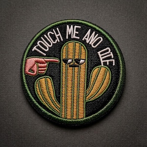 Può includere: Una toppa ricamata circolare con sfondo nero e bordo verde. Raffigura un cactus giallo con un'espressione imbronciata e due braccia. Una mano rosa punta verso il cactus. Il testo TOUCH ME AND DIE è ricamato in bianco.