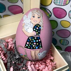 Huevo de Pascua pintado a mano, niño y conejitos