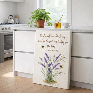 May include: A canvas print featuring a watercolor illustration of lavender and bees. The text reads "Kind words are like honey - sweet to the soul and healthy for the body. Proverbs 16:24 NLT."