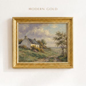 Vintage oil painting of a white stone cottage with a gray roof on a green hillside, surrounded by flowering bushes, a lone tree, and a dirt path under a cloudy sky, displayed in an ornate gold frame.
