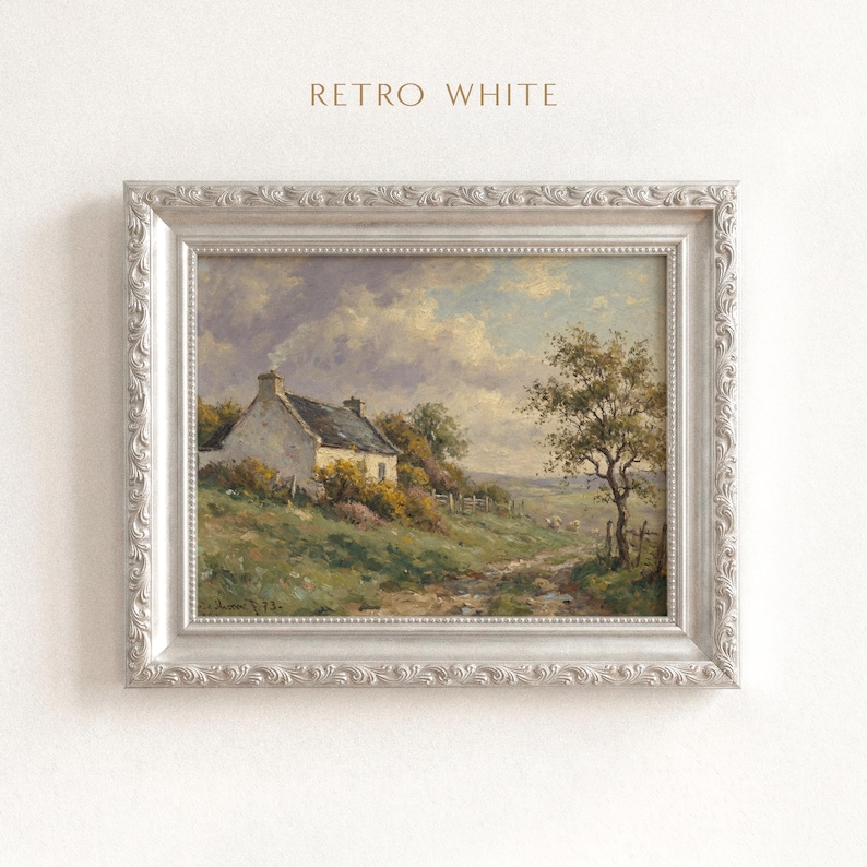 Vintage oil painting of a white stone cottage with a gray roof on a green hillside, surrounded by flowering bushes, a lone tree, and a dirt path under a cloudy sky, displayed in an ornate gold frame.