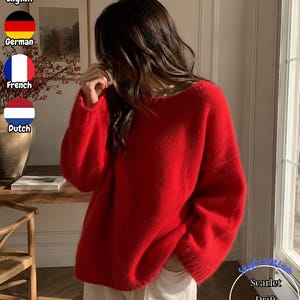 Könnte beinhalten: Ein leuchtend roter Langarmpullover mit Rundhalsausschnitt und einer flauschigen, strukturierten Strickoberfläche. Das Kleidungsstück hat eine lockere Passform mit gerippten Bündchen und einem passenden gerippten Saum für einen schlichten Look.