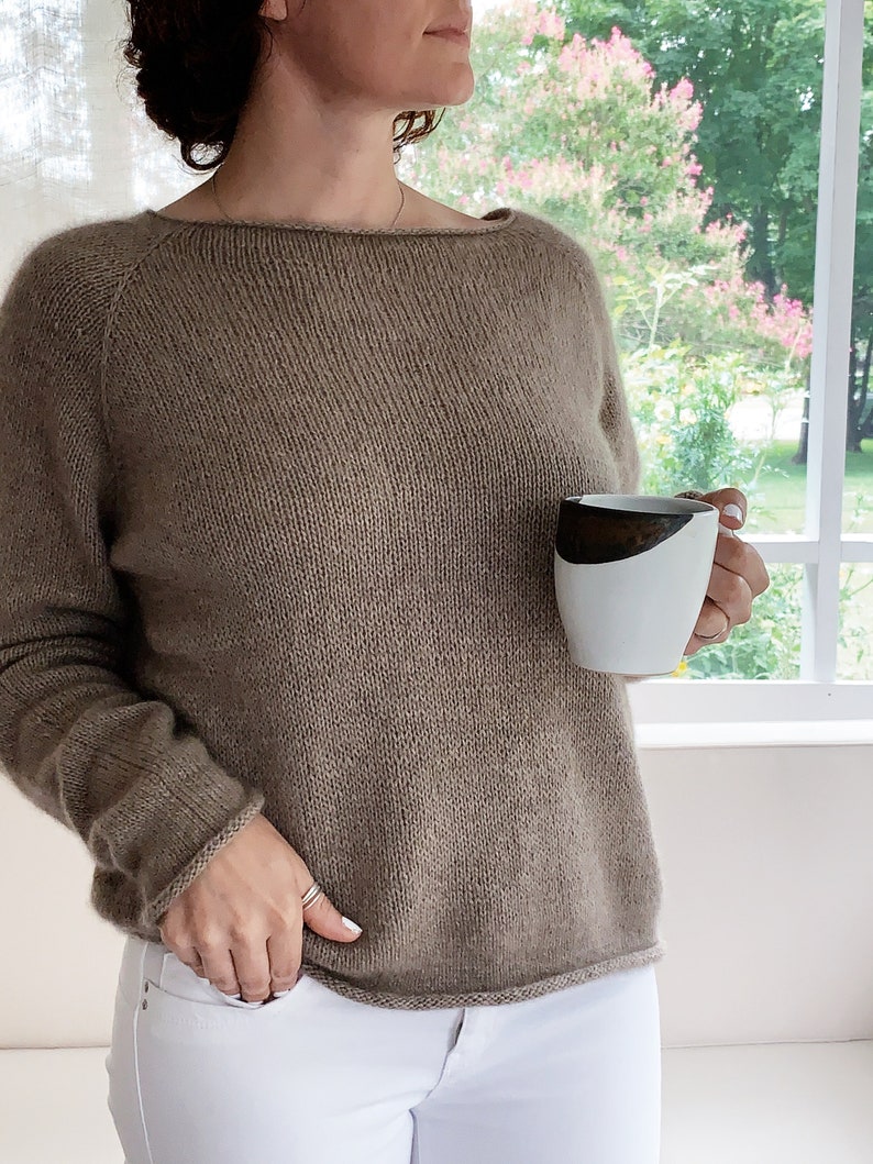May include: A brown knitted jumper with a boat neck and long sleeves. The jumper is made of a soft, comfortable material and has a relaxed fit.