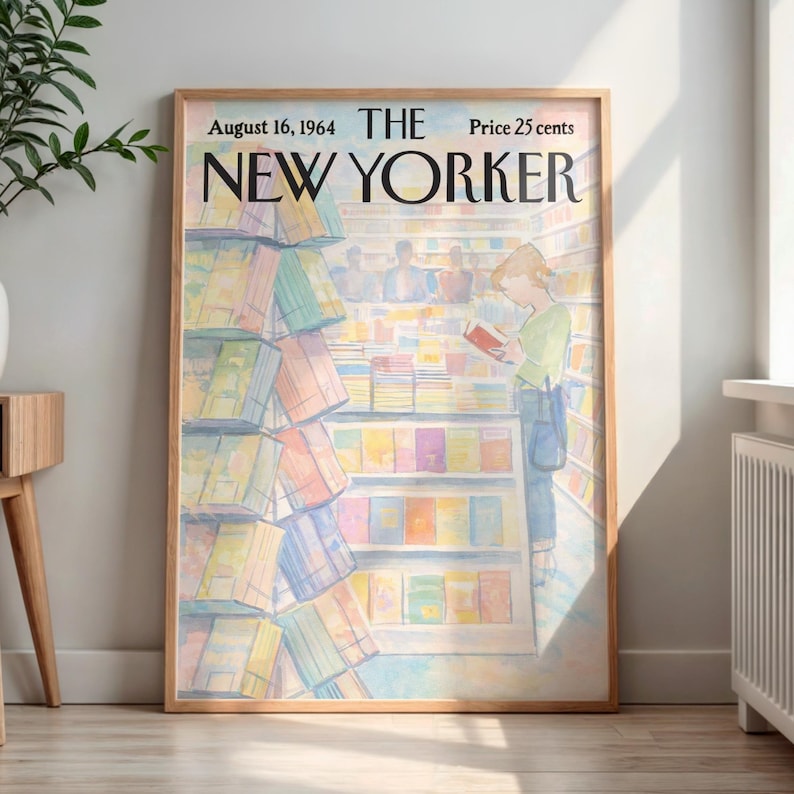 May include: A framed print of a New Yorker magazine cover from August 16, 1964. The illustration depicts a person reading in a bookstore, surrounded by colorful books. The frame is a light brown color.