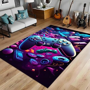 May include: A rectangular area rug with a vibrant, neon-colored video game controller design. The rug features a large, stylized controller in shades of blue and purple, surrounded by other gaming elements on a dark background.