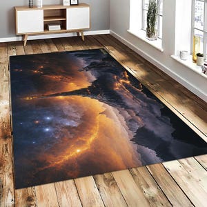 Könnte beinhalten: Ein rechteckiger Teppich mit einem Himmelslandschaftsdesign. Der Teppich zeigt eine lebendige Farbpalette aus Orange, Gelb und Blau mit einer detaillierten Darstellung einer kosmischen Szene. Das Design umfasst eine Bergkette und einen leuchtenden Nebel.