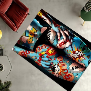 Può includere: Un tappeto rettangolare a tema fumetto. Il tappeto presenta uno sfondo blu con fumetti e parole d'azione come "BOOM!" e "RASH!" in colori vivaci. Il design include un'illustrazione stilizzata di una persona.