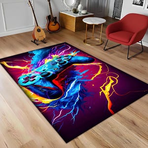 May include: A rectangular area rug featuring a vibrant, abstract design of a video game controller. The rug showcases a blue controller with red buttons, set against a backdrop of electric blue, yellow, and purple lightning bolts.