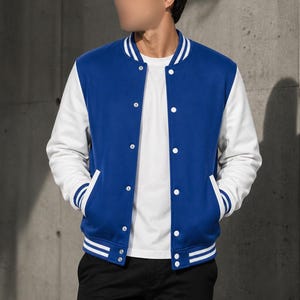 May include: A blue and white varsity jacket with a button-up front. The jacket has a blue body and white sleeves, with white and blue striped detailing on the cuffs and collar. The jacket has two front pockets.