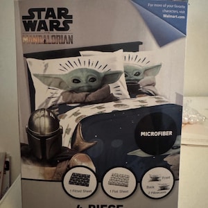 May include: A Star Wars Mandalorian 4-piece full sheet set. The set includes a fitted sheet, flat sheet, and two pillowcases. The design features the character Grogu, also known as Baby Yoda, and the Mandalorian helmet. The set is made of microfiber.