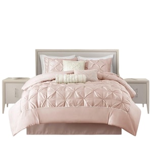 May include: A blush pink bed set with a pleated comforter, matching pillows, and a bed skirt. The set includes a headboard and two matching nightstands. The bedding has a satin finish and a white trim.