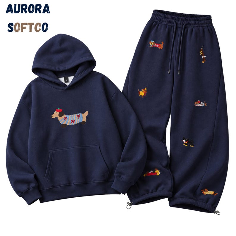 K&ouml;nnte beinhalten: Ein marineblaues Set aus Kapuzenpullover und Jogginghose mit gestickten Dackeln. Der Hoodie hat eine K&auml;ngurutasche und einen Dackel mit rotem Barett. Die Hose verf&uuml;gt &uuml;ber einen elastischen Kordelzug am Bund und elastische Beinabschl&uuml;sse.