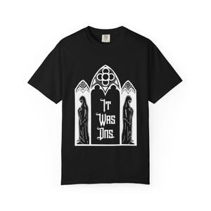 May include: Black t-shirt with a white graphic featuring a gothic arch design. The design includes two figures and the text "It Was Ins." A classic crew neck tee.