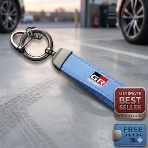 May include: A light blue keychain with a silver metal ring and clasp. The keychain has a black, red, and white "GR Sport" logo. The image also includes a "Ultimate Best Seller" and "Free Shipping" badge.