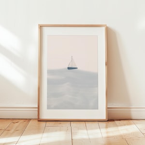 K&ouml;nnte beinhalten: Eine gerahmte Illustration eines Segelboots auf einem hellblauen Meer mit einem rosa Himmel im Hintergrund.