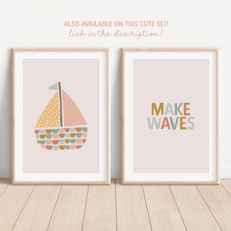 May include: Two framed art prints with a light pink background. One print features a sailboat with a yellow dotted sail, pink sail, and colorful details. The other print says "MAKE WAVES" in colorful letters. The text "ALSO AVAILABLE ON THIS CUTE SET! link in the description!" is at the top.