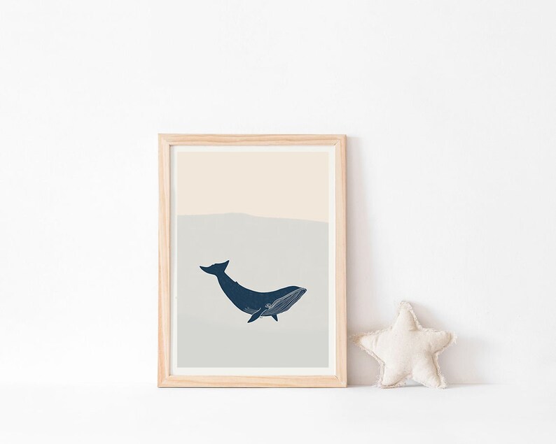 May include: A framed print of a blue whale with a light blue and beige background. The whale is swimming towards the right side of the image.