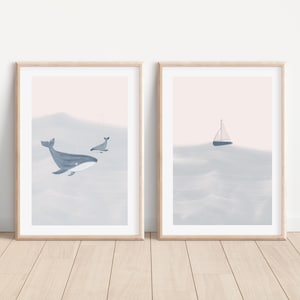 K&ouml;nnte beinhalten: Zwei gerahmte Drucke mit Aquarell-&Auml;sthetik. Der linke Druck zeigt einen blauen Wal und einen kleineren Wal, die in einem hellblauen Ozean schwimmen. Der rechte Druck zeigt ein Segelboot in einem hellblauen Ozean.