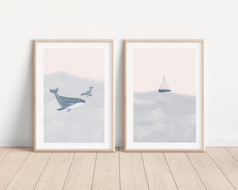 K&ouml;nnte beinhalten: Zwei gerahmte Drucke mit Aquarell-&Auml;sthetik. Der linke Druck zeigt einen blauen Wal und einen kleineren Wal, die in einem hellblauen Ozean schwimmen. Der rechte Druck zeigt ein Segelboot in einem hellblauen Ozean.