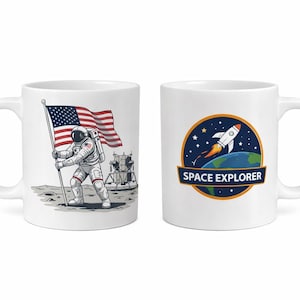 May include: Two white ceramic mugs. One mug features an astronaut planting the American flag on the moon. The other mug has a rocket ship design with the words "Space Explorer".